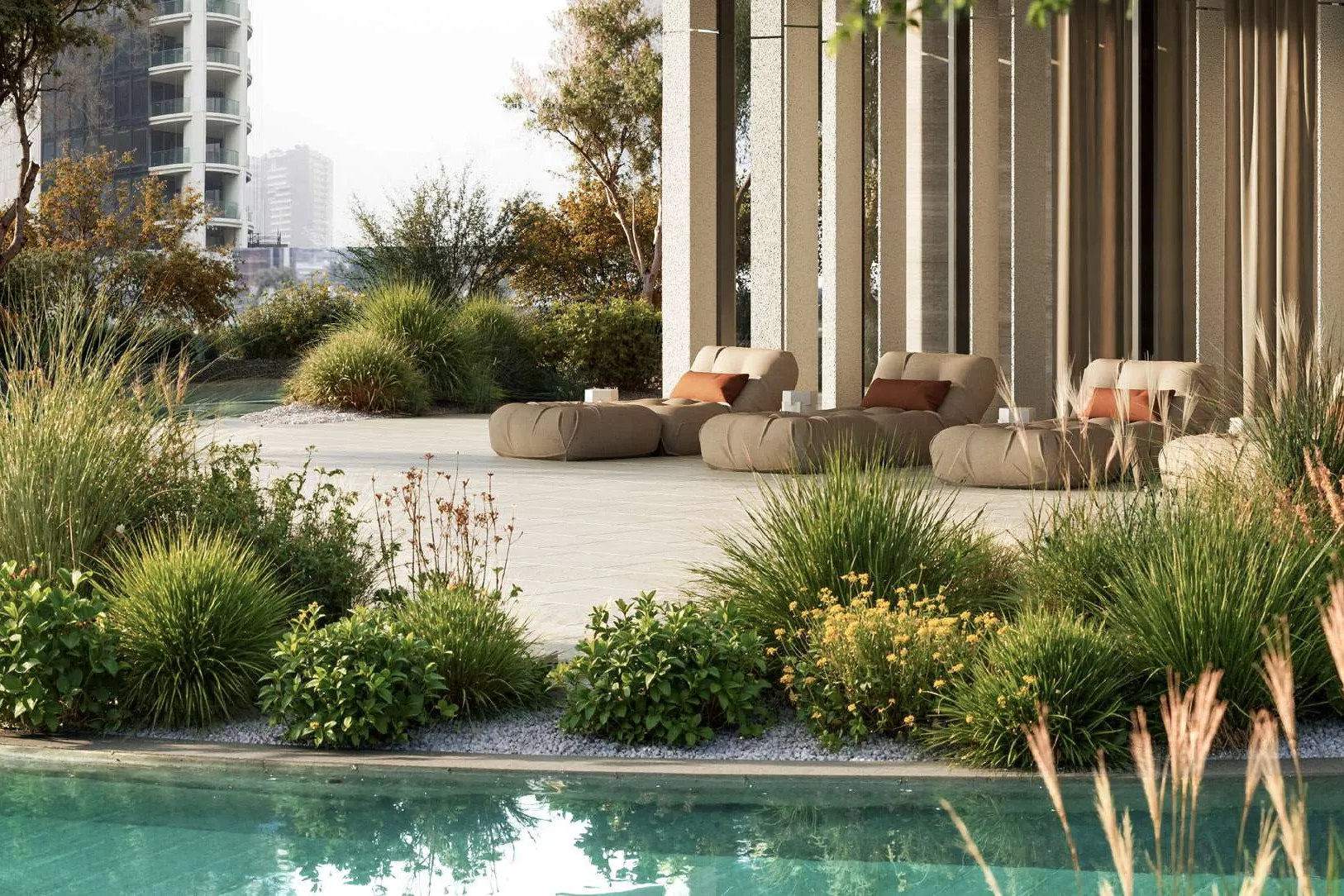 Pool edge with grasses and lounge seating under a shaded colonnade